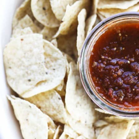 This Smoky Roasted Salsa is the little black dress of the salsa world; non-traditional, smoky, fine-textured, and slightly spicy with a bold flavour that’ll knock you out, this salsa is equally wonderful when dunked with chips, poured over meats in a slow-cooker, or spooned and baked on enchiladas. I have yet to find a commercially available salsa that matches this for depth, complexity, and utter fabulousness. I make this salsa in bulk -to the tune of a bushel each of tomatillos and plum tomatoes- every summer because the boys and their friends alike act neglected and depressed if we run out before summer rolls around. While it is far and away best when prepared in season, you can make it year ‘round in a salsa emergency. Believe me when I tell you if you run out, it will be a salsa emergency.