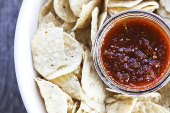 This Smoky Roasted Salsa is the little black dress of the salsa world; non-traditional, smoky, fine-textured, and slightly spicy with a bold flavour that’ll knock you out, this salsa is equally wonderful when dunked with chips, poured over meats in a slow-cooker, or spooned and baked on enchiladas. I have yet to find a commercially available salsa that matches this for depth, complexity, and utter fabulousness. I make this salsa in bulk -to the tune of a bushel each of tomatillos and plum tomatoes- every summer because the boys and their friends alike act neglected and depressed if we run out before summer rolls around. While it is far and away best when prepared in season, you can make it year ‘round in a salsa emergency. Believe me when I tell you if you run out, it will be a salsa emergency.