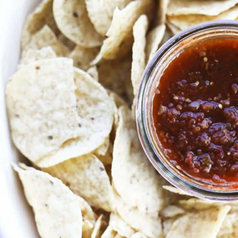 This Smoky Roasted Salsa is the little black dress of the salsa world; non-traditional, smoky, fine-textured, and slightly spicy with a bold flavour that’ll knock you out, this salsa is equally wonderful when dunked with chips, poured over meats in a slow-cooker, or spooned and baked on enchiladas. I have yet to find a commercially available salsa that matches this for depth, complexity, and utter fabulousness. I make this salsa in bulk -to the tune of a bushel each of tomatillos and plum tomatoes- every summer because the boys and their friends alike act neglected and depressed if we run out before summer rolls around. While it is far and away best when prepared in season, you can make it year ‘round in a salsa emergency. Believe me when I tell you if you run out, it will be a salsa emergency.