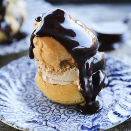 Homemade Cream Puffs filled with ice cream and topped with hot fudge sauce for profiteroles.