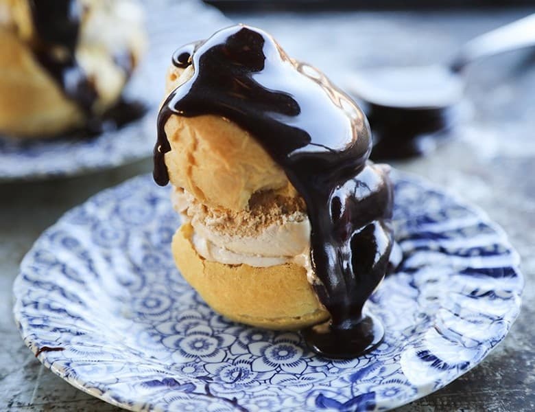Homemade Cream Puffs filled with ice cream and topped with hot fudge sauce for profiteroles.