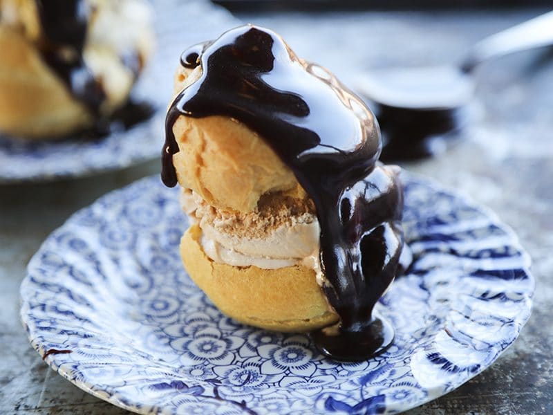 Homemade Cream Puffs filled with ice cream and topped with hot fudge sauce for profiteroles.