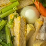 corn cobs and vegetables in a stockpot to make corn stock with text overlay describing the photo