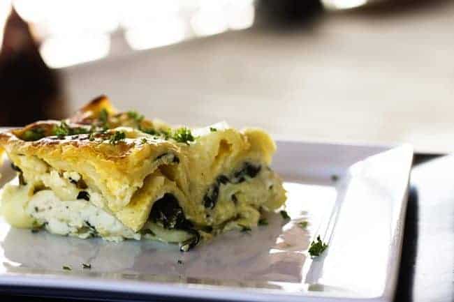 Roasted Garlic Spinach Alfredo Lasagna with a scandalous chicken in the background from Foodie with Family