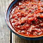 Cobalt blue pottery bowl with brown rim, filled with five minute restaurant style chipotle salsa