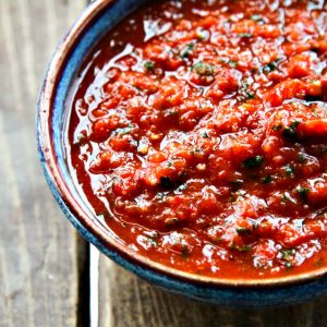 Cobalt blue pottery bowl with brown rim, filled with five minute restaurant style chipotle salsa