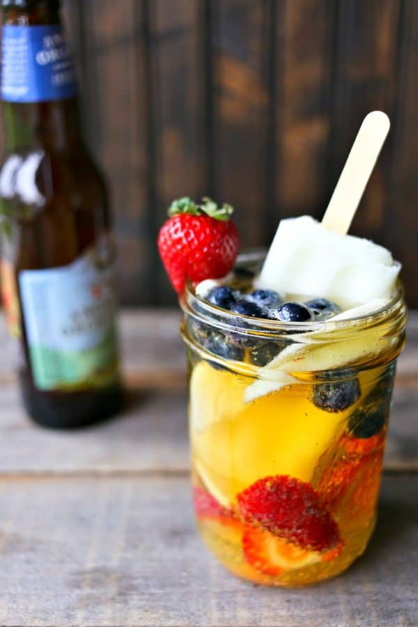 Hard Cider Sangria-by-the-Glass is fresh fruits soaked in crisp hard cider with a lime ice pop stir stick. 