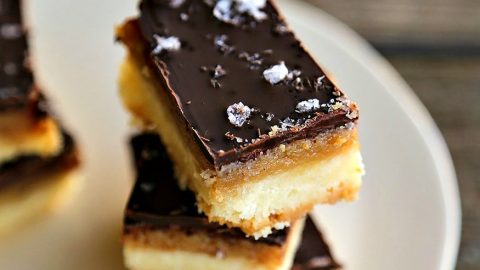 Selfish Bars - Chocolate Caramel Sugar Cookie Bars, shortbread, caramel, melted chocolate, maldon sea salt on white ceramic plate, wooden backgroundThese are worth being selfish over!