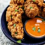 Garlic Buffalo Sauce with chicken tenders in a blue plate.