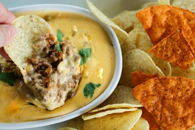 Ooey-gooey, chile studded heavenly queso smothers your favourite chili for a bowl of the ultimate Chili Con Queso Dip. Get those chips ready to go!