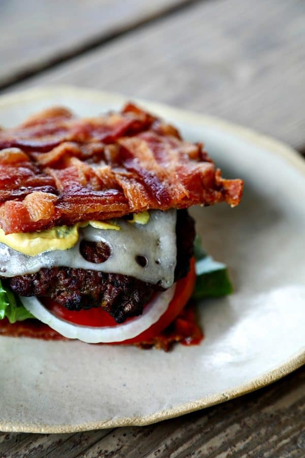 This Low-Carb Bacon Bun Swiss Burger is still seriously indulgent with a basket-weave bacon bun, melted Swiss cheese, a ground chuck burger, a hint of Dijon mustard, leaf lettuce, fresh tomato, and sweet onion. Hang onto that last bit of summer!