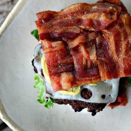 This Low-Carb Bacon Bun Swiss Burger is still seriously indulgent with a basket-weave bacon bun, melted Swiss cheese, a ground chuck burger, a hint of Dijon mustard, leaf lettuce, fresh tomato, and sweet onion. Hang onto that last bit of summer!