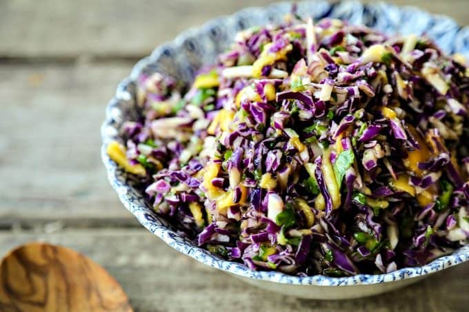 Spicy Mango Slaw is crunchy purple cabbage with a hint of tropical sweetness from just barely ripe mango, and the tart and tangy lime juice and honey dressing gets a flavour boost from minced red onion and fragrant cilantro.