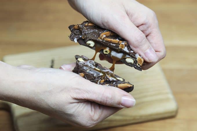 Chocolate Covered Caramel Stuffed Pretzels; crunchy sourdough pretzels enrobed in dark chocolate with a sprinkling of flaky sea salt that ooze perfectly gooey caramel when you bite into them.