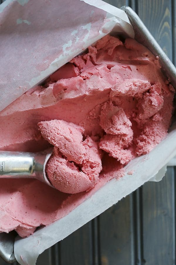 3-ingredient strawberry ice cream, parchment paper lined aluminum bread pan, rustic wooden table