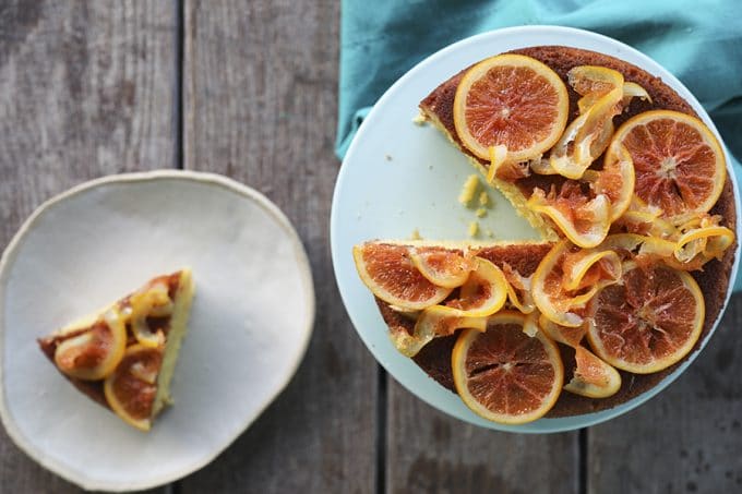 Orange Olive Oil Cake with Candied Oranges is light, has a fine crumb, is perfectly moist but not sopping, is beautifully fragrant of oranges, has just a hint of warm cardamom, and is festooned with thin slices of orange lovingly candied in honey and cardamom syrup.