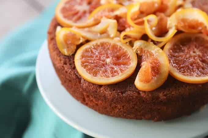 Orange Olive Oil Cake with Candied Oranges is light, has a fine crumb, is perfectly moist but not sopping, is beautifully fragrant of oranges, has just a hint of warm cardamom, and is festooned with thin slices of orange lovingly candied in honey and cardamom syrup.