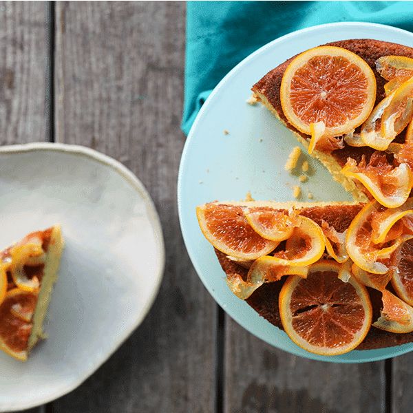 Orange Olive Oil Cake with Candied Oranges is light, has a fine crumb, is perfectly moist but not sopping, is beautifully fragrant of oranges, has just a hint of warm cardamom, and is festooned with thin slices of orange lovingly candied in honey and cardamom syrup.