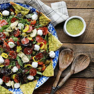 Supreme Pizza Salad: this salad is no boring, average salad. Mixed greens are tossed with crisped pepperoni, pesto pita chips, artichoke hearts, mini mozzarella balls, marinated olives, cherry tomatoes, sun dried tomatoes, pepperoncini, and a flavourful pesto vinaigrette.