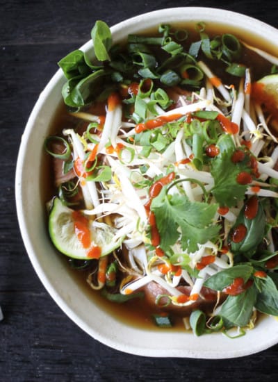 Easy Beef Pho Recipe in a white bowl with stainless steel chopsticks.
