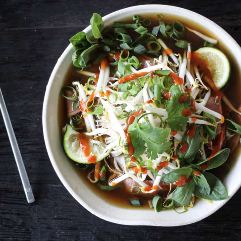 Easy Beef Pho Recipe in a white bowl with stainless steel chopsticks.