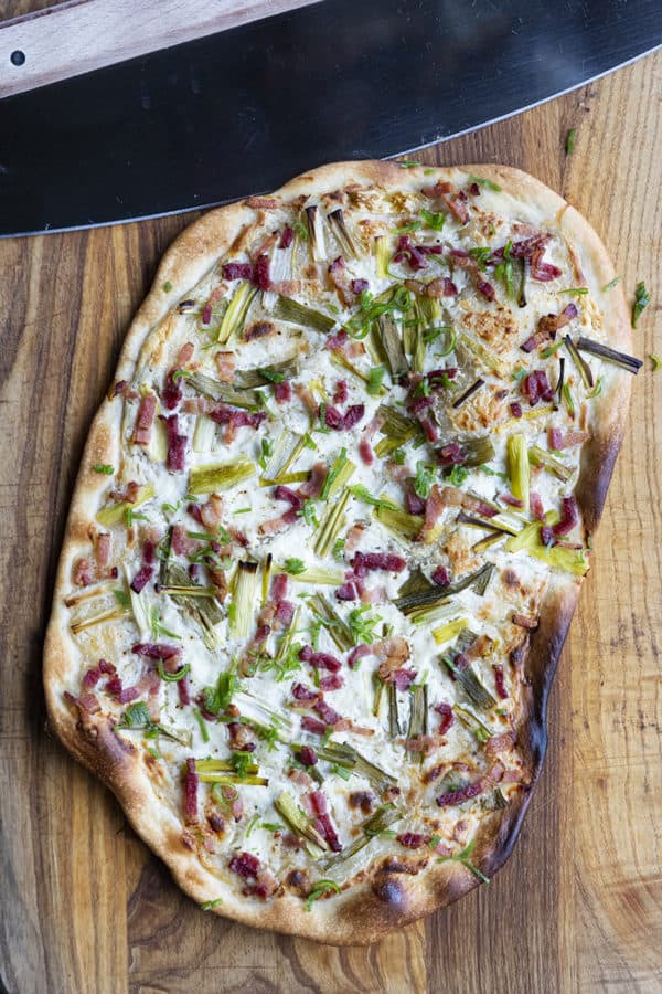 Flammekueche, tarte Flambée, or flammkuchen is a fast and easy bacon and onion pizza type flatbread made with crème fraîche or sour cream. No yeast needed!