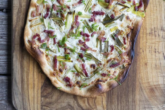 Flammekueche, tarte Flambée, or flammkuchen is a fast and easy bacon and onion pizza type flatbread made with crème fraîche or sour cream. No yeast needed!