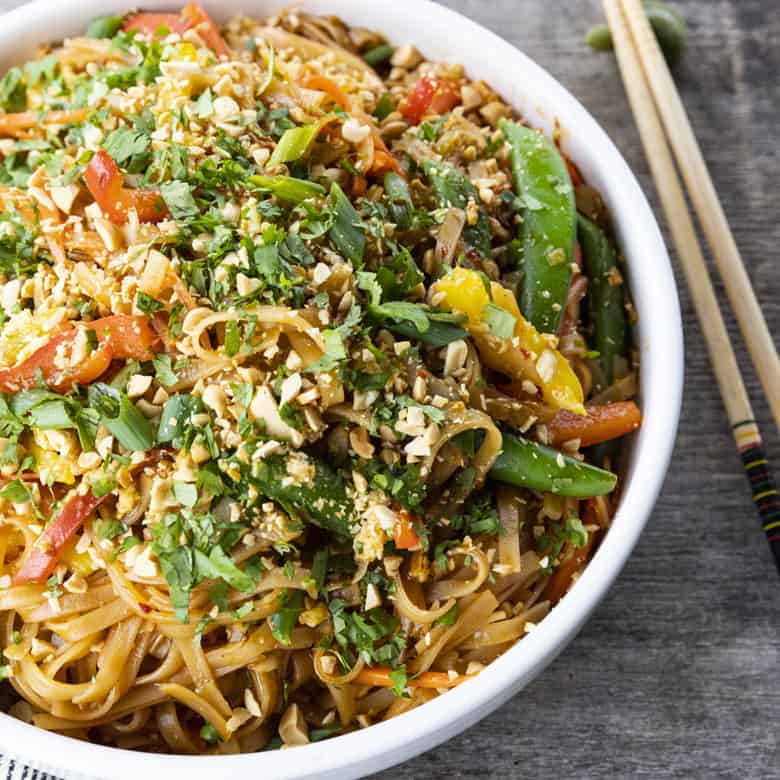 Chewy rice noodles scandalously loaded with crisp tender vegetables, a flavourful garlic and ginger sauce, and eggs make up our divine Rice Noodle Stir Fry.