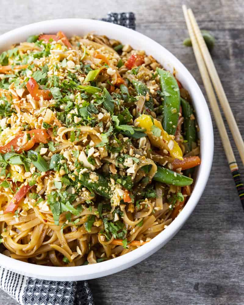 Chewy rice noodles scandalously loaded with crisp tender vegetables, a flavourful garlic and ginger sauce, and eggs make up our divine Rice Noodle Stir Fry.