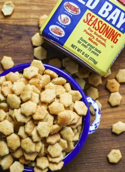 Old Bay Seasoned Oyster Crackers in a blue and white bowl with a canister of Old Bay Seasoning.