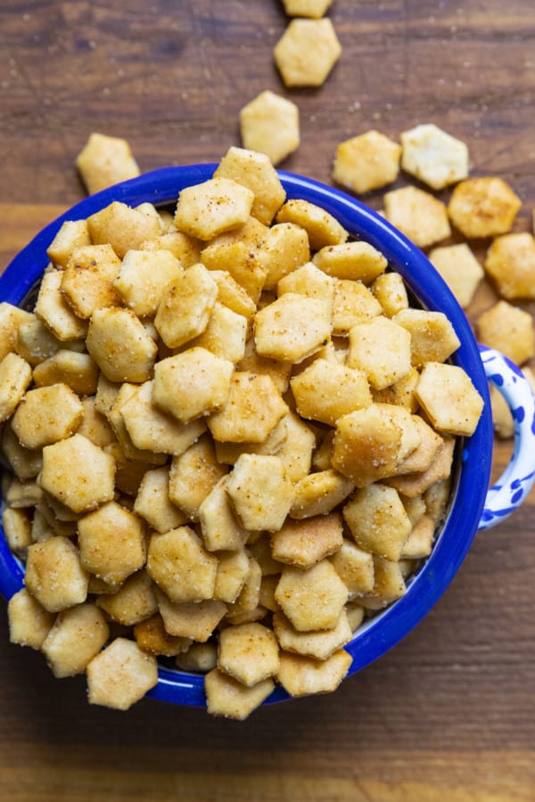 Old Bay Seasoned Oyster Crackers in a blue and white bowl with a canister of Old Bay Seasoning.