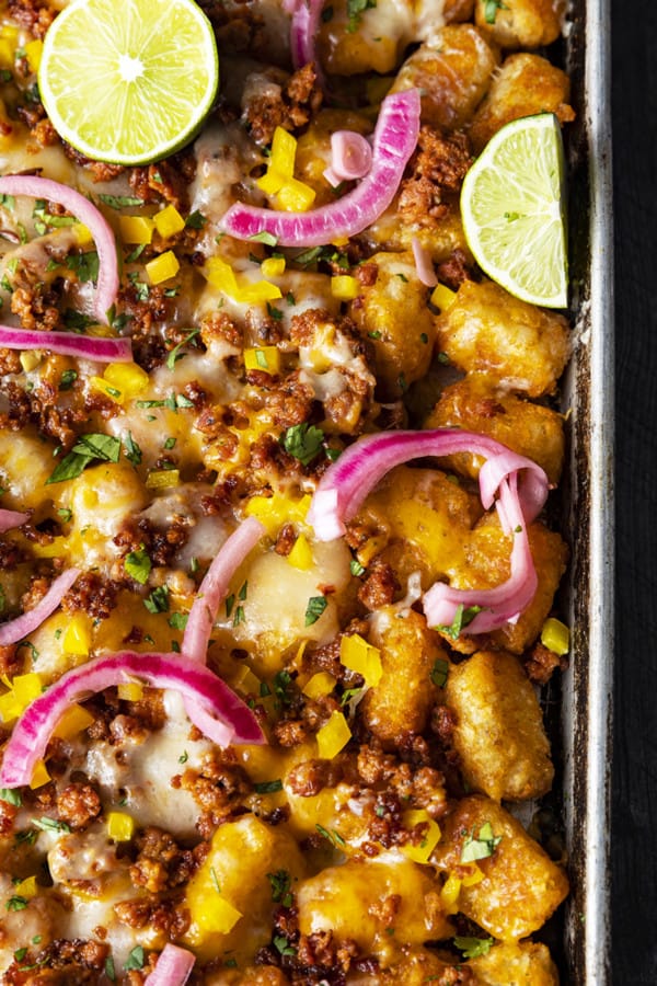 Change up Nacho Night by serving crave-ably good Tater Tot Nachos a.k.a. Totchos. These irresistible crispy baked tots are topped with spicy Chorizo, gooey melted Cheddar, pickled onions, and other nacho goodies!