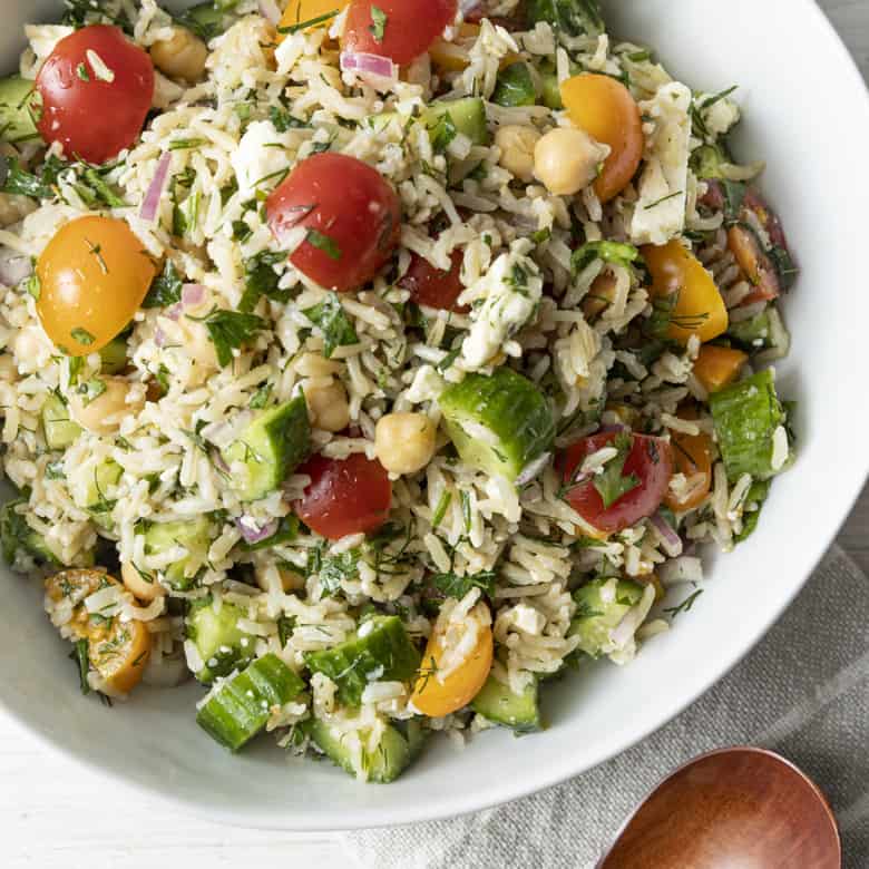 This delightful chilled Grain Salad is chock full of nutty brown rice, herbs, garbanzo beans, cucumbers, tomatoes, feta cheese, and red onions with a simple olive oil and lemon juice dressing. Make a batch of this to stash in the fridge and lunch is in the bag all week!