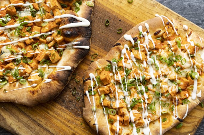 Tender cubes of Spicy Buffalo chicken, blue cheese crumbles or another cheese of your choice, thinly sliced green onions, and a drizzle of blue cheese dressing or ranch dressing top flatbread proving that great food doesn't have to be complicated! Buffalo Chicken Flatbread is equally fabulous as a great appetizer for game day or as an easy dinner.