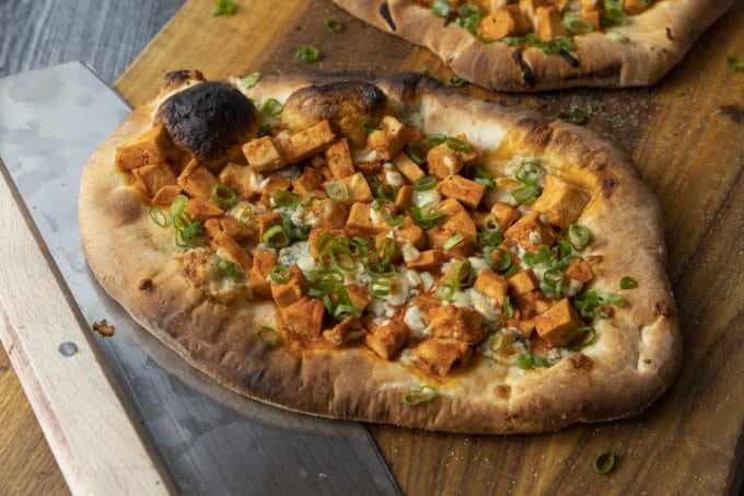 Tender cubes of Spicy Buffalo chicken, blue cheese crumbles or another cheese of your choice, thinly sliced green onions, and a drizzle of blue cheese dressing or ranch dressing top flatbread proving that great food doesn't have to be complicated! Buffalo Chicken Flatbread is equally fabulous as a great appetizer for game day or as an easy dinner.