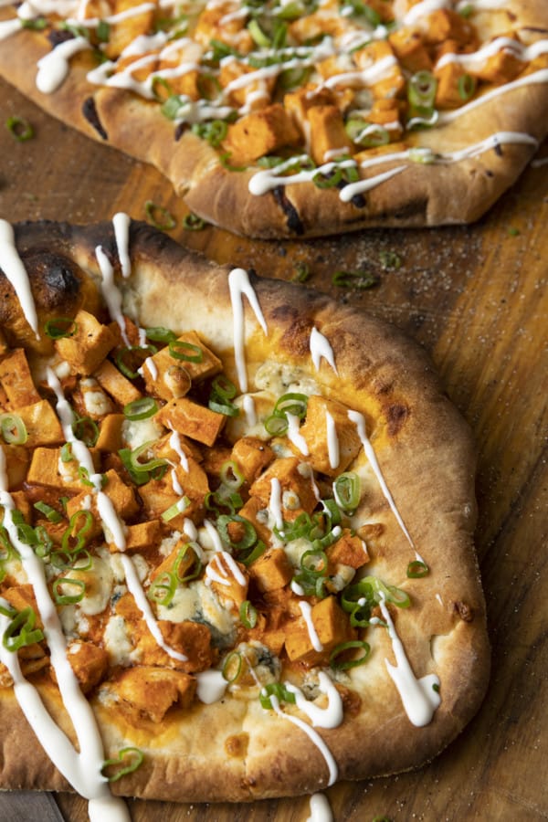 Tender cubes of Spicy Buffalo chicken, blue cheese crumbles or another cheese of your choice, thinly sliced green onions, and a drizzle of blue cheese dressing or ranch dressing top flatbread proving that great food doesn't have to be complicated! Buffalo Chicken Flatbread is equally fabulous as a great appetizer for game day or as an easy dinner.
