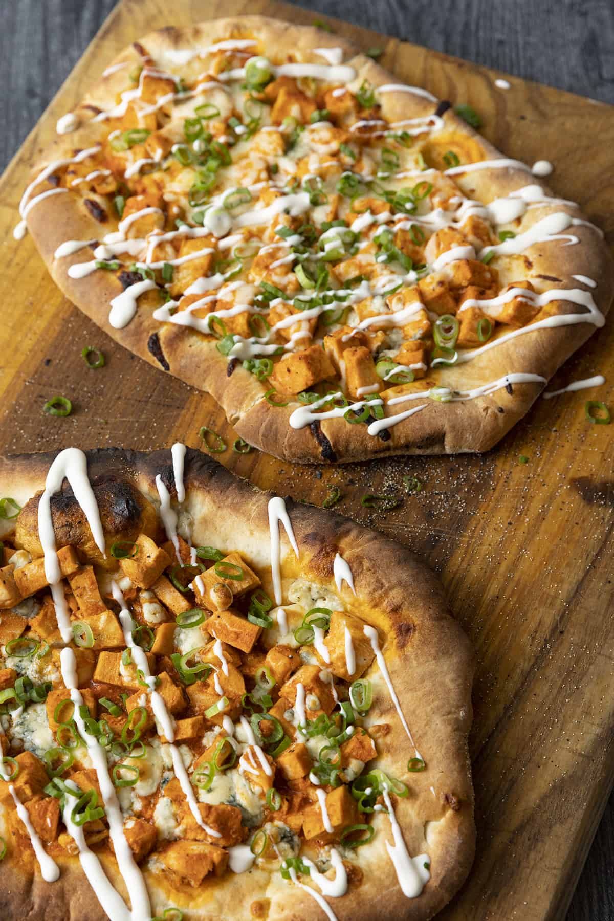 Tender cubes of Spicy Buffalo chicken, blue cheese crumbles or another cheese of your choice, thinly sliced green onions, and a drizzle of blue cheese dressing or ranch dressing top flatbread proving that great food doesn't have to be complicated! Buffalo Chicken Flatbread is equally fabulous as a great appetizer for game day or as an easy dinner.