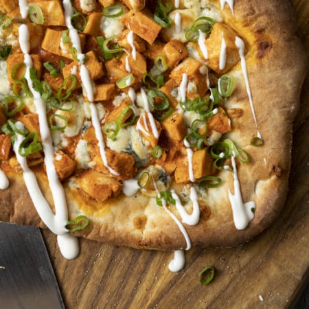 Tender cubes of Spicy Buffalo chicken, blue cheese crumbles or another cheese of your choice, thinly sliced green onions, and a drizzle of blue cheese dressing or ranch dressing top flatbread proving that great food doesn't have to be complicated! Buffalo Chicken Flatbread is equally fabulous as a great appetizer for game day or as an easy dinner.