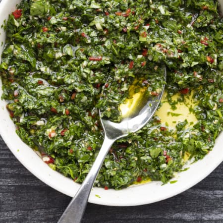 This Argentinian style chimichurri sauce recipe is one of the most versatile and flavourful sauces around. Traditionally served with grilled steak and sausages, this fresh herb and garlic sauce is also incredible with chicken, fish, vegetables, meatballs, potatoes, and so much more!