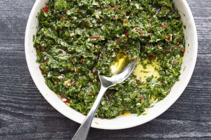 This Argentinian style chimichurri sauce recipe is one of the most versatile and flavourful sauces around. Traditionally served with grilled steak and sausages, this fresh herb and garlic sauce is also incredible with chicken, fish, vegetables, meatballs, potatoes, and so much more!