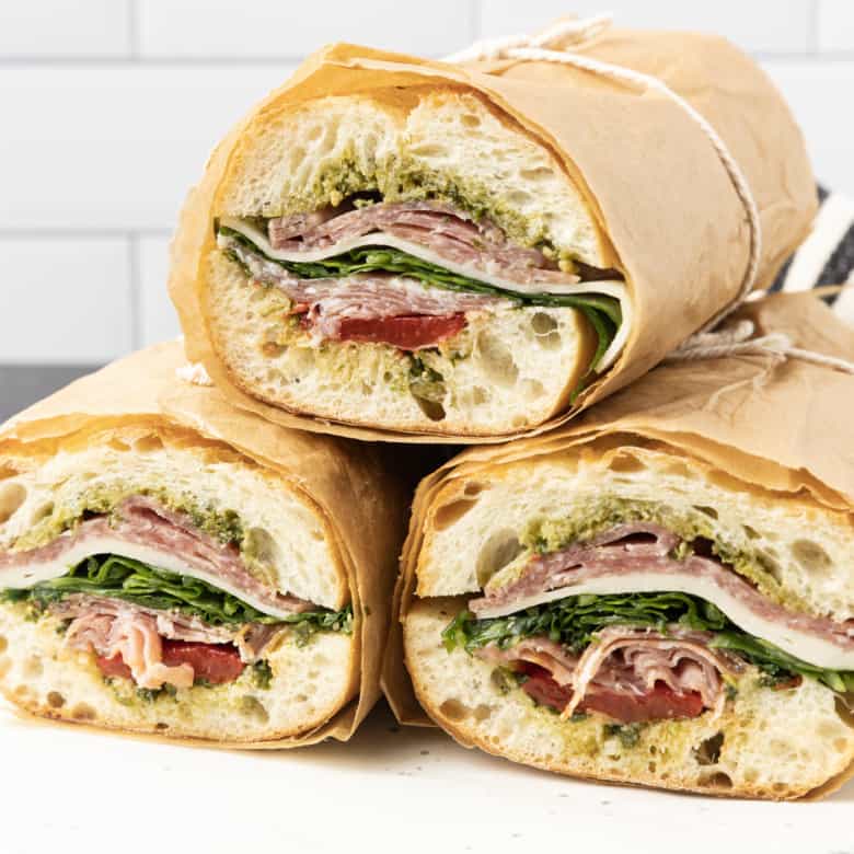 This is no ordinary Salami Sandwich; a crusty baguette is stuffed to bursting with a variety of salamis, roasted red pepper, pesto sauce, provolone cheese, fresh basil, and dressed arugula, then tightly wrapped and stashed in the refrigerator overnight. Then you can slice it all up and arrange it on a platter for a party or stretch it out for up to 5 days! And let me tell you, if you slice a little off of this every day for lunch with a cup of soup or bag of chips, you're going to feel very clever indeed. If you're feeling generous, pop it in a lunch bag for a school lunch that will make your kid the envy of the school.