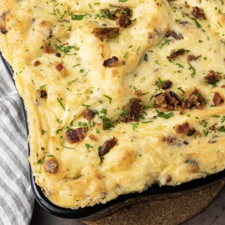 Get ready to dig into a baking dish filled with piping hot, irresistibly golden crusted, super creamy Twice Baked Mashed Potatoes. This make-ahead perfect side dish combines everything you love about creamy mashed potatoes, baked and twice baked potatoes; grated cheese, sour cream, crispy bacon, fresh herbs, and a whisper thin crispy crust at the edges. The only thing better than the taste of Twice Baked Mashed Potatoes casserole is its convenience. You can make it up to three days ahead of time and reheat before serving or you can make it, wrap it tightly, and freeze it for up to a month.