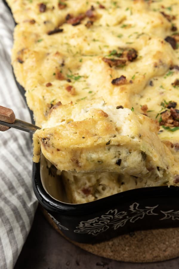 Get ready to dig into a baking dish filled with piping hot, irresistibly golden crusted, super creamy Twice Baked Mashed Potatoes. This make-ahead perfect side dish combines everything you love about creamy mashed potatoes, baked and twice baked potatoes; grated cheese, sour cream, crispy bacon, fresh herbs, and a whisper thin crispy crust at the edges. The only thing better than the taste of Twice Baked Mashed Potatoes casserole is its convenience. You can make it up to three days ahead of time and reheat before serving or you can make it, wrap it tightly, and freeze it for up to a month.