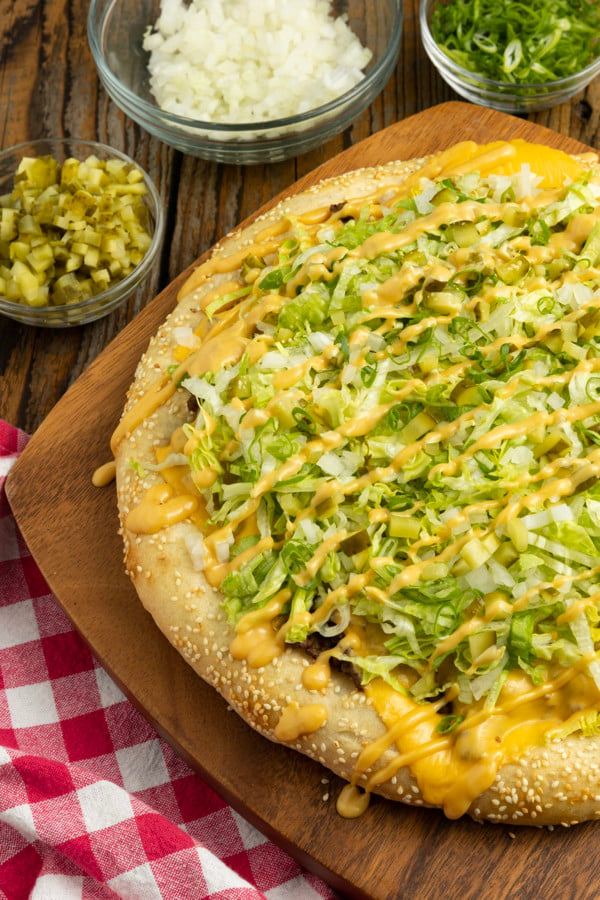 Big Mac Pizza brings the classic “two all beef patties, special sauce, lettuce, cheese, pickles, onions, on a sesame seed bun” taste that you love to pizza in this irresistible recipe! It’s got that craveable fast-food flavour but made fresher than the real thing in your own home for pizza night.