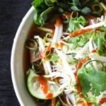 Easy Pho recipe: fragrant beef broth, slices of beef, rice noodles, sprouts, cilantro and basil, hot peppers, and a squeeze of lime!