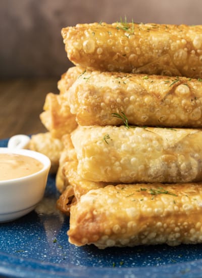 In an irresistible twist on the classic Reuben sandwich these Corned Beef Egg Rolls feature shatteringly crisp egg roll wrappers stuffed with salty corned beef, briny sauerkraut, nutty Swiss cheese and a little Dijon mustard. Dunk in homemade Thousand Island Dip or serve with horseradish, wasabi, or spicy brown mustard. The recipe includes instructions for pan frying, air frying, and baking the egg rolls.