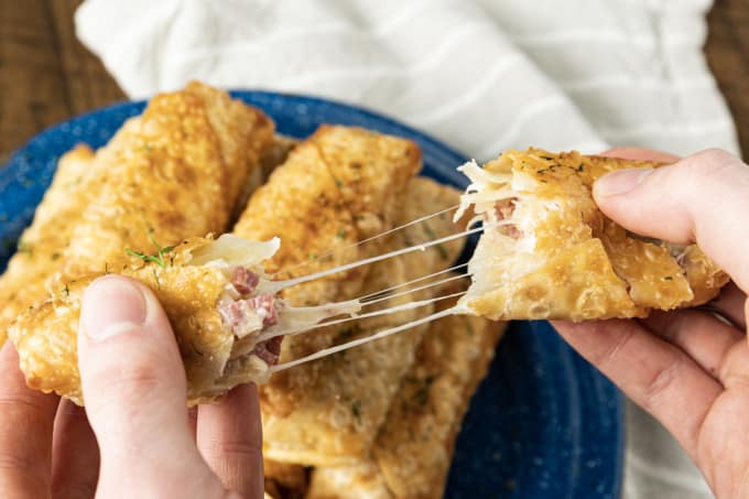 In an irresistible twist on the classic Reuben sandwich these Corned Beef Egg Rolls feature shatteringly crisp egg roll wrappers stuffed with salty corned beef, briny sauerkraut, nutty Swiss cheese and a little Dijon mustard. Dunk in homemade Thousand Island Dip or serve with horseradish, wasabi, or spicy brown mustard. The recipe includes instructions for pan frying, air frying, and baking the egg rolls.