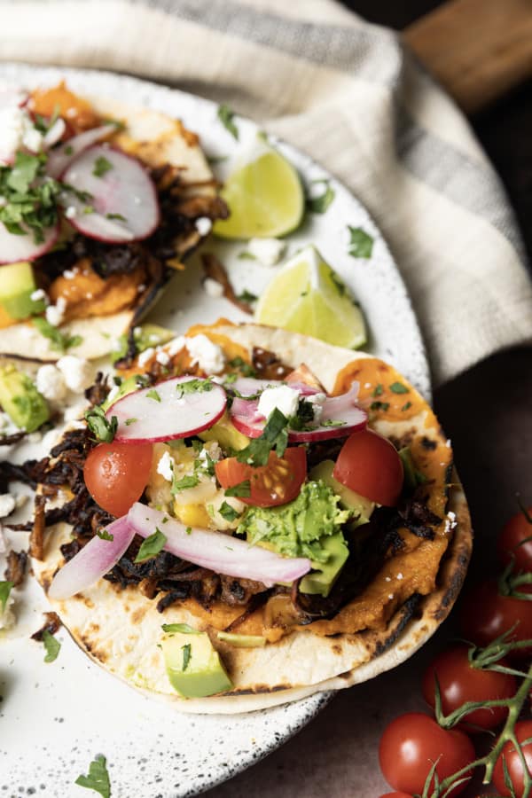 This crispy mushroom taco recipe with the works is for all my obsessive mushroom loving friends. It’s unapologetically mushroom forward, so this is not for you if you’re not into fungi. It’s almost laughably easy to make this substantial meatless taco recipe. Roasting the seasoned mushrooms on a metal sheet pan in a hot oven gives them delectable crispy edges.