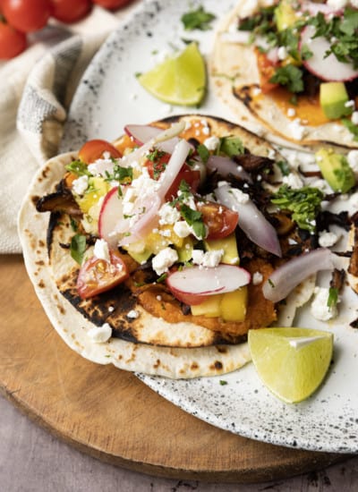 This crispy mushroom taco recipe with the works is for all my obsessive mushroom loving friends. It’s unapologetically mushroom forward, so this is not for you if you’re not into fungi. It’s almost laughably easy to make this substantial meatless taco recipe. Roasting the seasoned mushrooms on a metal sheet pan in a hot oven gives them delectable crispy edges.