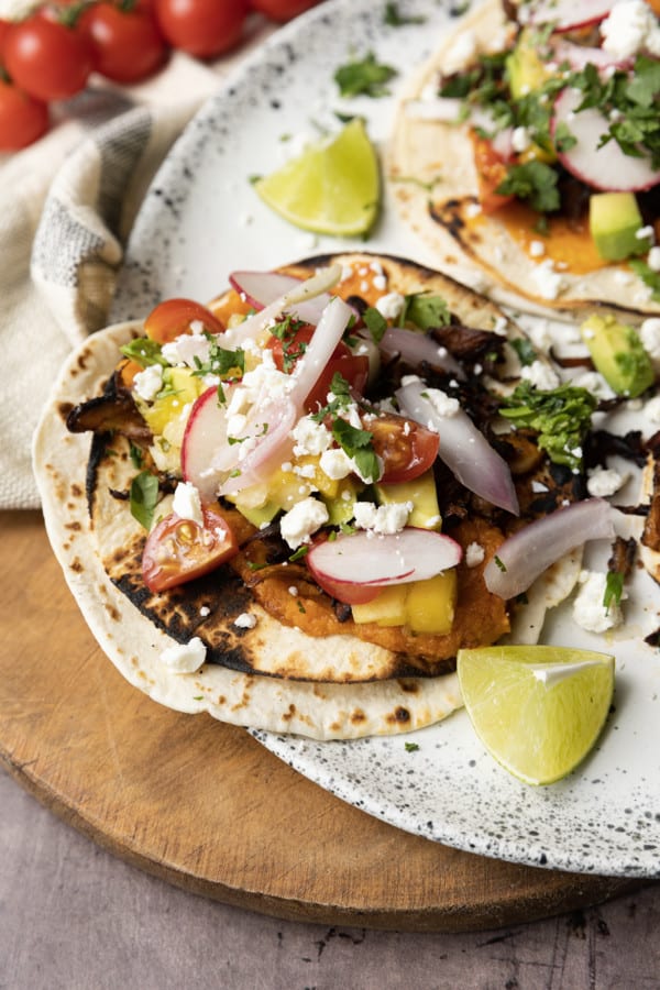 This crispy mushroom taco recipe with the works is for all my obsessive mushroom loving friends. It’s unapologetically mushroom forward, so this is not for you if you’re not into fungi. It’s almost laughably easy to make this substantial meatless taco recipe. Roasting the seasoned mushrooms on a metal sheet pan in a hot oven gives them delectable crispy edges.